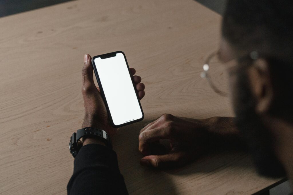 Person holding a smartphone with a blank white screen, symbolizing a poor user experience and design failure.