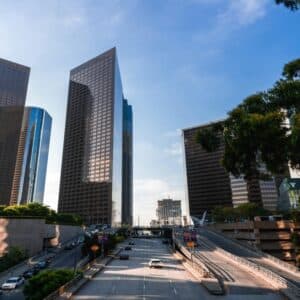 Skyscrapers lining a central Los Angeles avenue with traffic flowing beneath, representing the fast pace of digital business in LA.